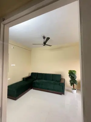 a green couch in a living room with a ceiling at Le Divine C3 Premium 1bhk Apartment 100meters from Guruwayur temple in Guruvāyūr
