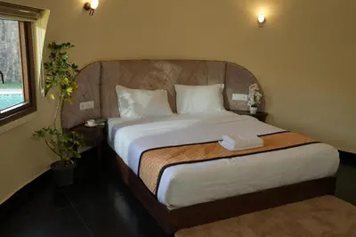 a bedroom with a large bed with white sheets at Lake Lagoon Moonhills in Mennānyam