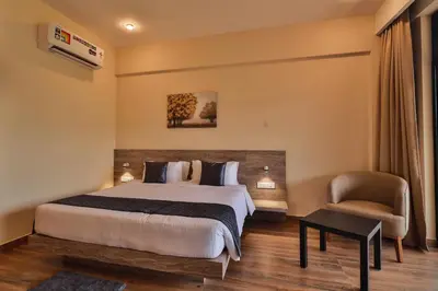 a hotel room with a bed and a chair at Serene Aqua Hills in Kozhikode