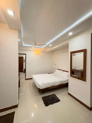 a bedroom with a bed and a mirror on the wall at Isha suites in Mysore