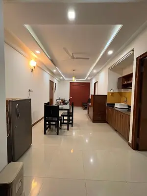a kitchen and dining room with a table and chairs at Isha suites in Mysore
