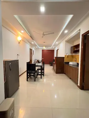 a kitchen and dining room with a table and chairs at Isha suites in Mysore
