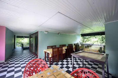 a room with a table and chairs on a floor at Snow Drops Resort in Vythiri