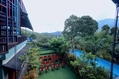a balcony with red chairs and a swimming pool at Snow Drops Resort in Vythiri