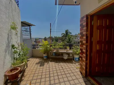 a patio with potted plants and a table on a balcony at Mindful Rooftop Yoga Stay in Gokulam Bright, Airy Private Family Terrace Apartment in Mysore