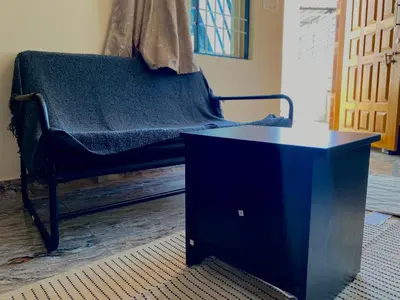 a blue chair with a table in a room at Mindful Rooftop Yoga Stay in Gokulam Bright, Airy Private Family Terrace Apartment in Mysore