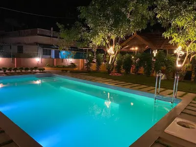 a swimming pool at night with lights at Ponyo Stays in Cochin
