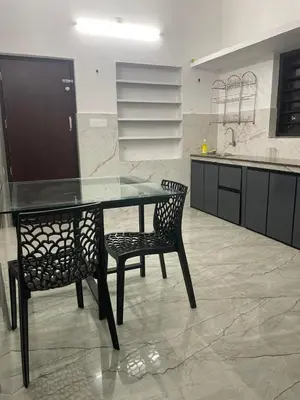 a kitchen with a glass table and two chairs at Mount holidays in Meppādi