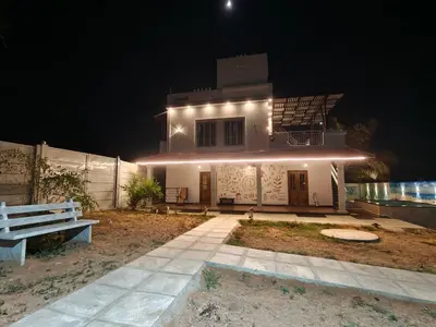 a house with lights on the side of it at night at JRD House in Mysore
