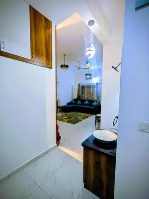 a bathroom with a sink and a living room at JRD House in Mysore