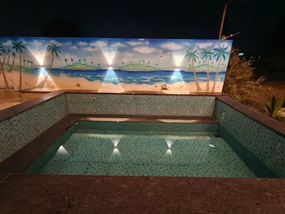a swimming pool with a painting on the wall at JRD House in Mysore