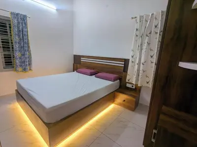 a bedroom with a bed with lights on it at JRD House in Mysore