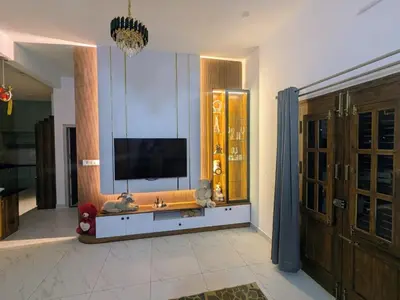 a living room with a flat screen tv on a wall at JRD House in Mysore