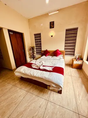 a bedroom with a large bed with red pillows at Ronz Vista Mount Villa in Padinjarathara