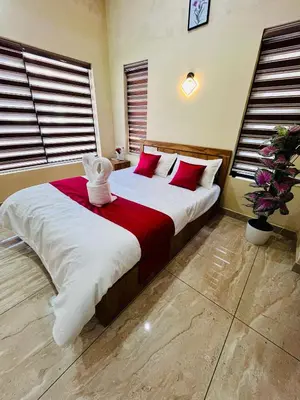 a bedroom with a large bed with red and white pillows at Ronz Vista Mount Villa in Padinjarathara