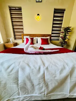 a large white bed with a swan decoration on it at Ronz Vista Mount Villa in Padinjarathara