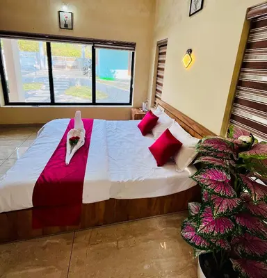a bedroom with a large bed with red pillows at Ronz Vista Mount Villa in Padinjarathara