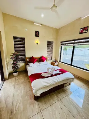 a bedroom with a large bed and a large window at Ronz Vista Mount Villa in Padinjarathara