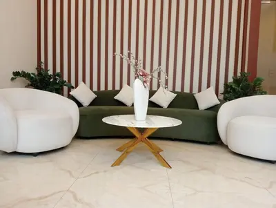 a living room with two white chairs and a green couch at Aloka Cordial Luxury Residences in Trichūr