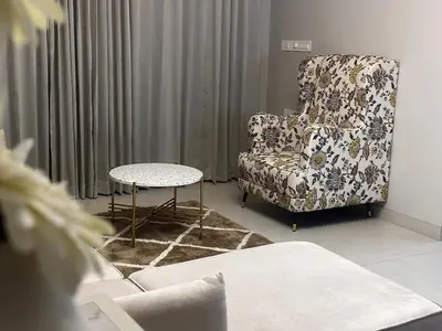 a living room with a chair and a table at Aloka Cordial Luxury Residences in Trichūr