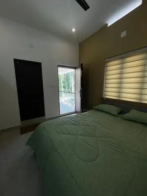 a bedroom with a large bed with a large window at Vijay Home Stays in Batheri