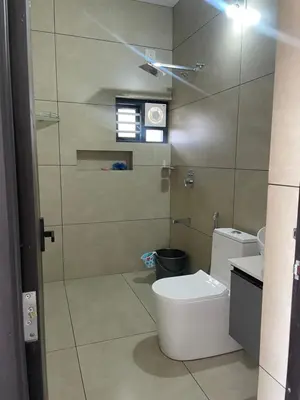 a bathroom with a toilet and a glass shower at Vijay Home Stays in Batheri
