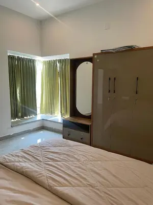 a bedroom with a large bed and a large mirror at Vijaya Home Stay in Batheri