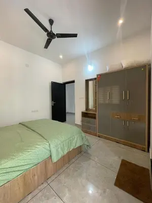a bedroom with a bed and a ceiling fan at Vijaya Home Stay in Batheri