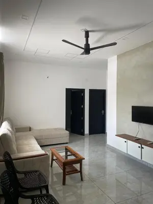a living room with a couch and a tv at Vijaya Home Stay in Batheri