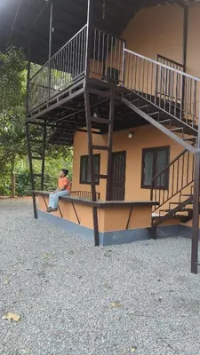 a man sitting on a bench in front of a building at Vythiri Silent Leaf in Wayanad