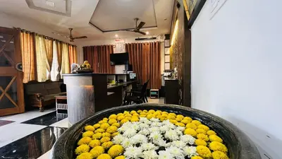 a large bowl of yellow and white flowers in a room at Raja Residency Near isha Foundation Adiyogi in Coimbatore
