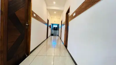 an empty hallway with doors and a tile floor at Raja Residency Near isha Foundation Adiyogi in Coimbatore