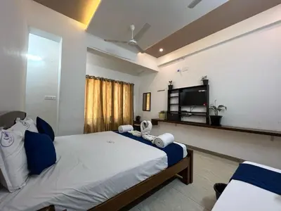 a bedroom with a large bed and a flat screen tv at Raja Residency Near isha Foundation Adiyogi in Coimbatore