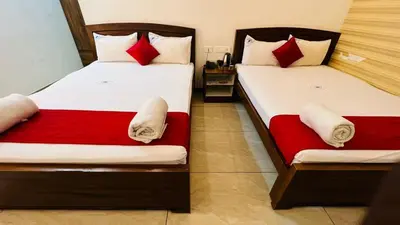 two beds in a hotel room with red and white sheets at Raja Residency Near isha Foundation Adiyogi in Coimbatore