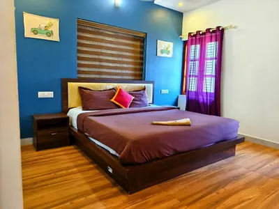 a bedroom with a large bed with blue walls at z in wayanad in Kalpetta