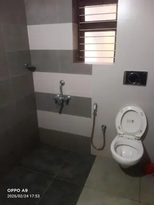 a bathroom with a toilet and a window at Nalukettu Veedu in Thottada