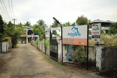a sign on a fence in front of a house at Ashiyana Homes in Nedumbassery