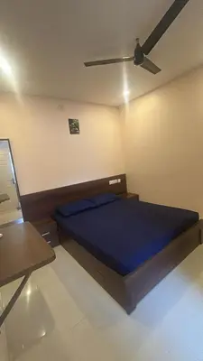 a bedroom with a bed with a ceiling fan at Kalpaka in Guruvāyūr