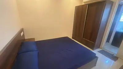 a small bedroom with a blue bed and a window at Kalpaka in Guruvāyūr