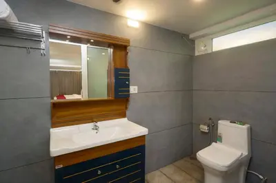 a bathroom with a sink and a toilet and a mirror at Akanta Cherai Beach Resort in Cochin