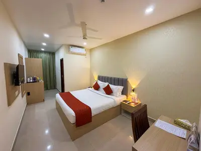 a hotel room with a bed and a table and chairs at PANCHAVADY RESIDENCy in Kodungallūr