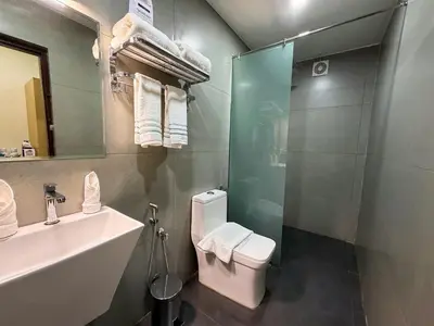 a bathroom with a toilet and a sink and a shower at PANCHAVADY RESIDENCy in Kodungallūr
