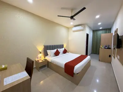 a hotel room with a bed and a desk at PANCHAVADY RESIDENCy in Kodungallūr