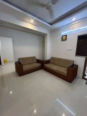a living room with two couches and a flat screen tv at Thirteen in Guruvāyūr
