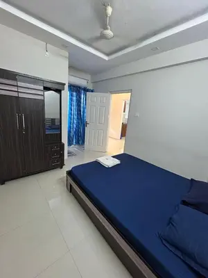 a bedroom with a blue bed and a mirror at Thirteen in Guruvāyūr