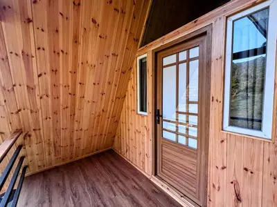 a wooden cabin with a door and windows at AURA Resort kookal kodaikanal in Kūkkāl