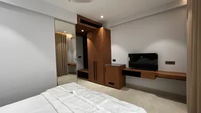 a bedroom with a bed and a flat screen tv at Cloud Nine Hotel - Kuthuparamba in Kuthuparamba