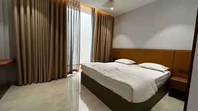 a bedroom with a bed and a large window at Cloud Nine Hotel - Kuthuparamba in Kuthuparamba