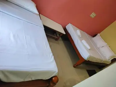 a bed and a chair in a room at ISIRI Rooms in Mysore