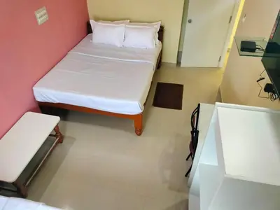 a small room with a bed in a room at ISIRI Rooms in Mysore